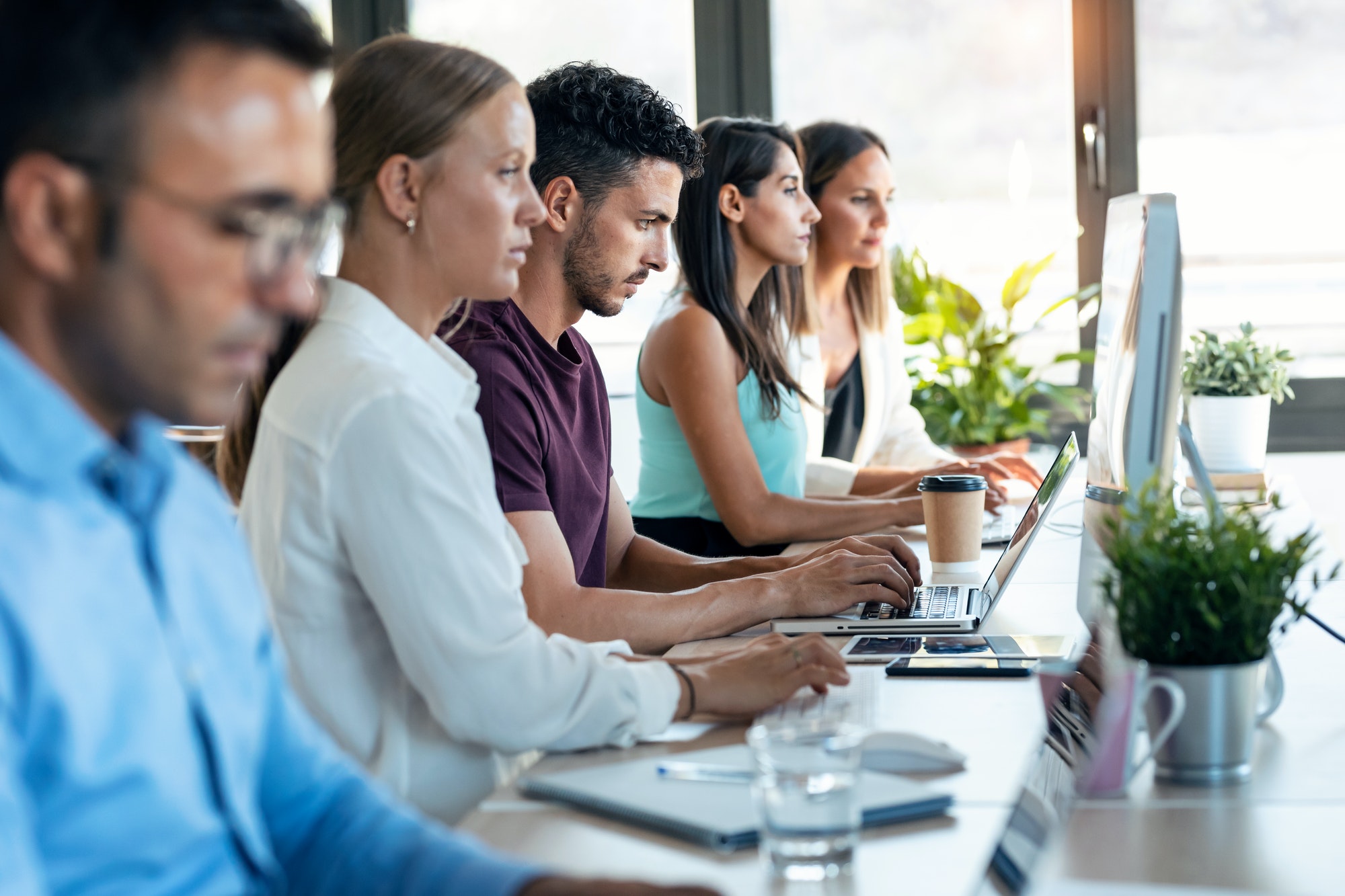 successful-concentrated-business-team-working-together-with-computers-on-coworking-place-.jpg
